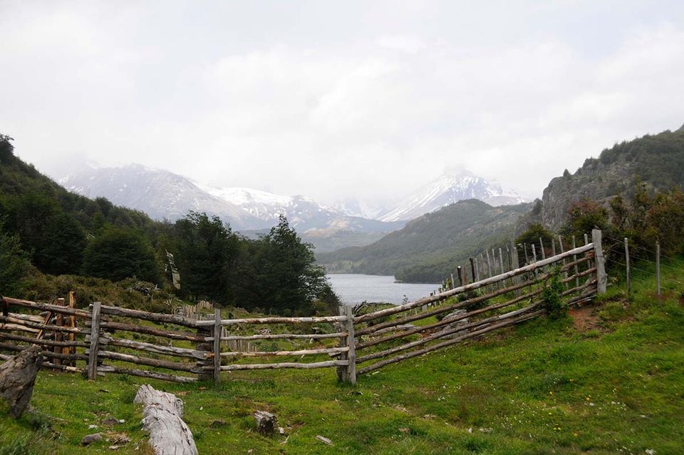 A beautiful landscape of the countryside in Patagonia with a wooden fence in the mid-ground.
